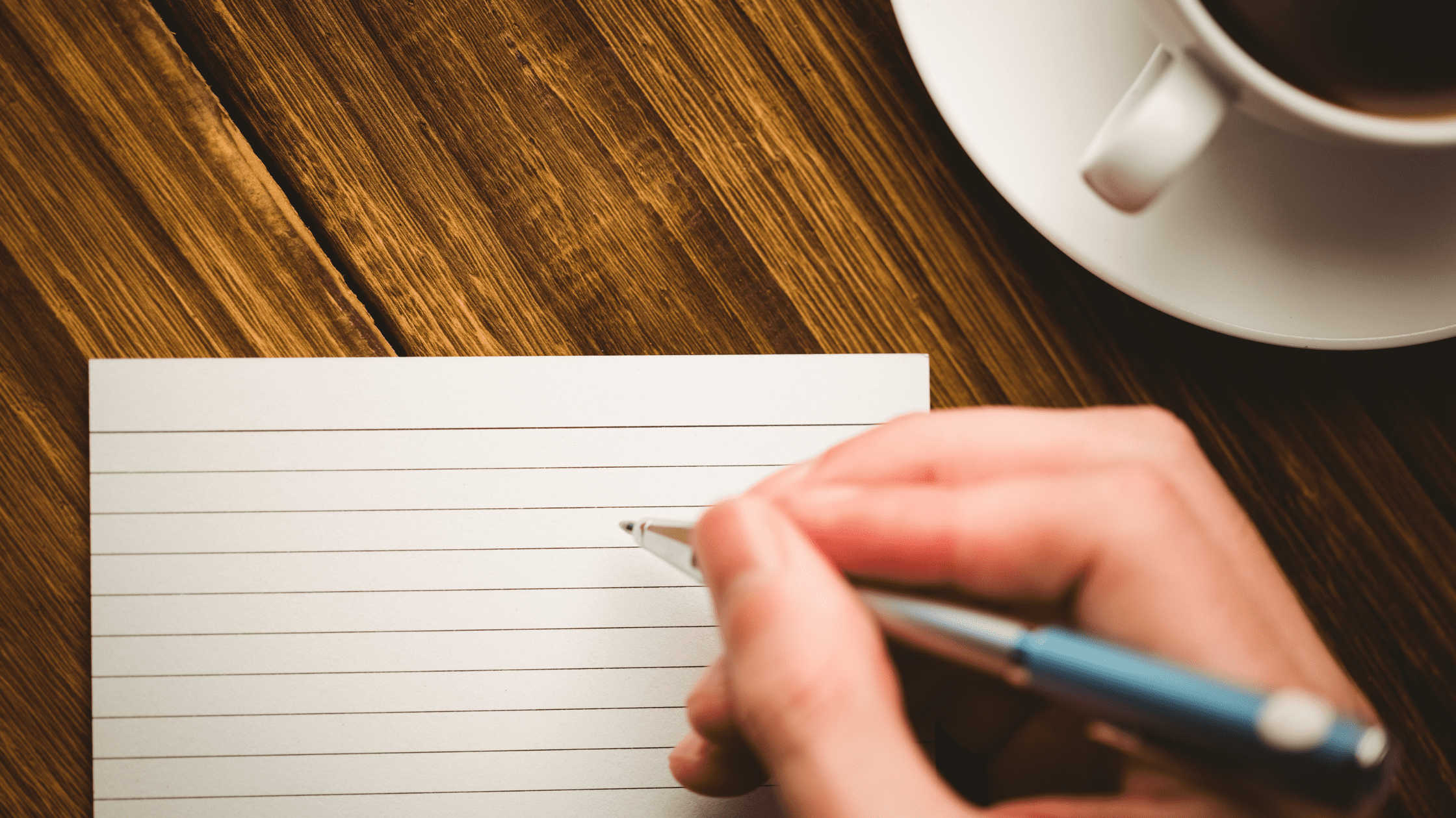 A pen held over an empty flashcard to be used for USMLE prep.